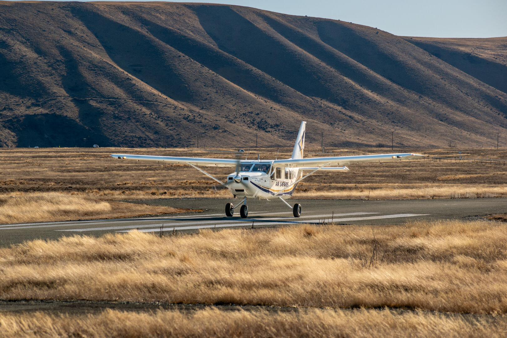 Air Safari airplane on runway with Lake Tekapo mountains
